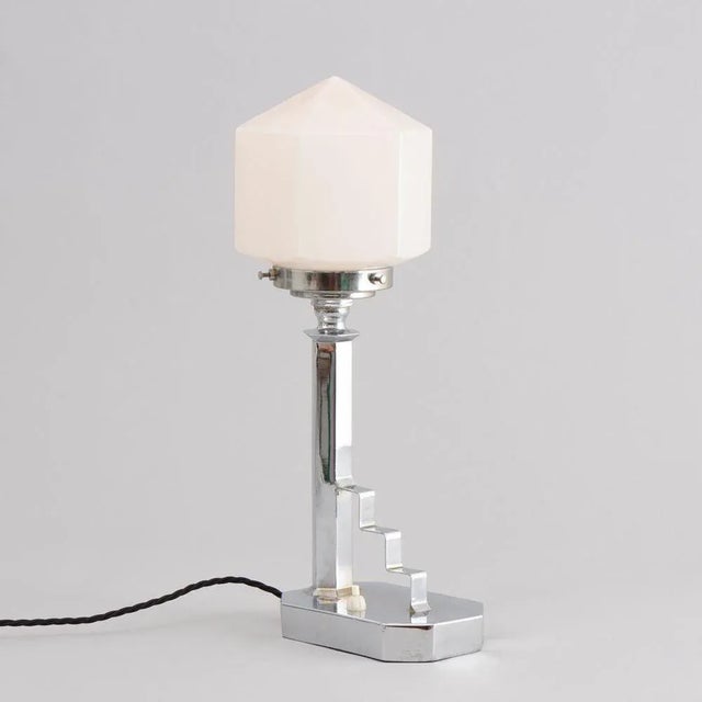 H: 42cm w: 21.5cm d: 13.5cm an art deco table lamp made in chrome with a step detail and a diamond shape glass shade. uk...