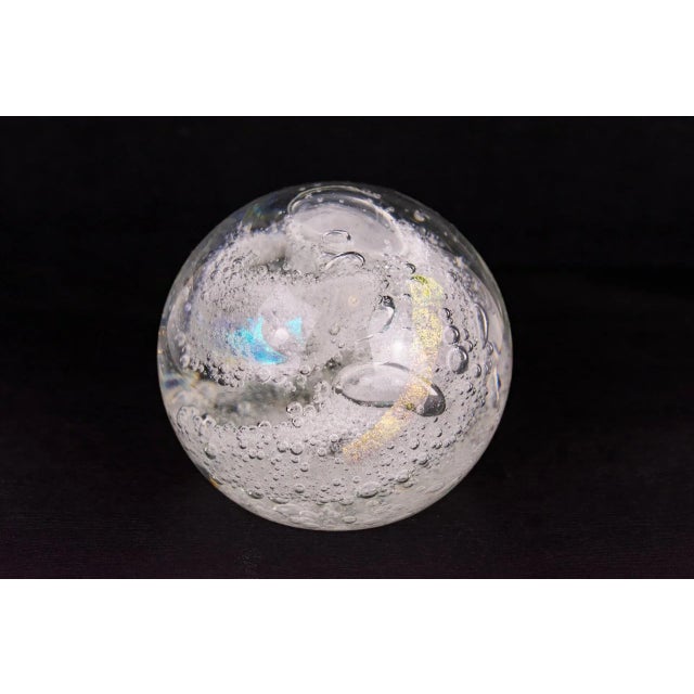 Vintage bubbly clear glass paper weight with light, iridescent swirls of blue and yellow tones. Handmade and signed by the...