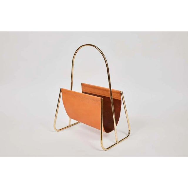 Carl Auböck model #4019-2 leather and brass magazine rack designed in the 1950s. This incredibly refined and sculptural...