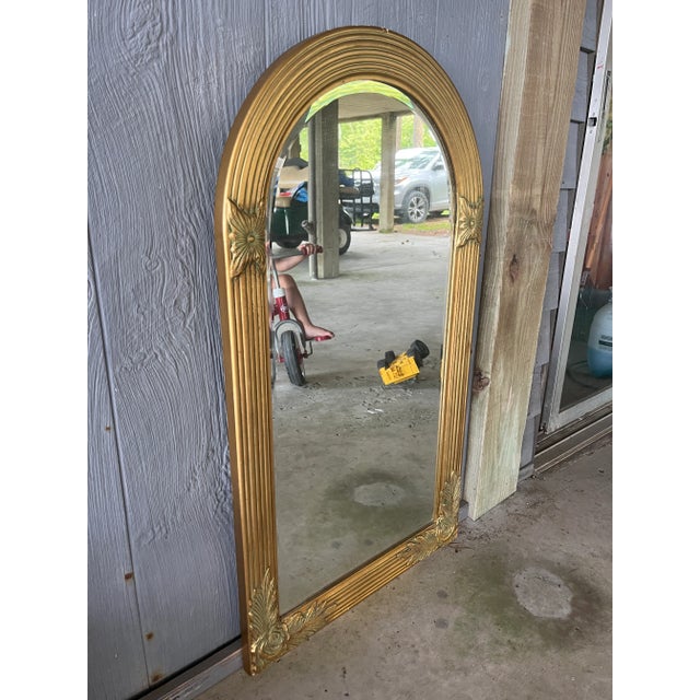 A fabulous 1950’s Hollywood Regency gold carved wood mirror with rosette details. A stunner above your mantle, show...