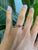 A rubellite tourmaline in a rich pink-red anchors this solid 14K yellow gold estate ring, flanked by two round pink...