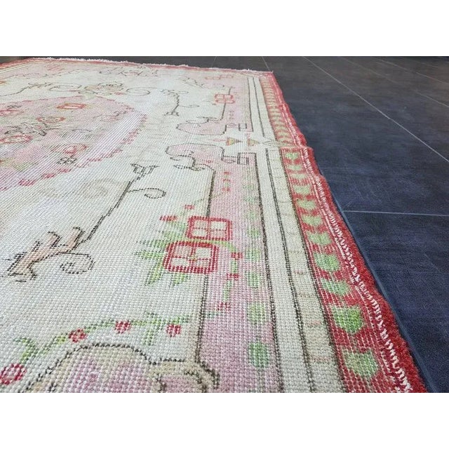 This is a vintage Turkish Oushak rug from the 1960s. The piece was hand-knotted.