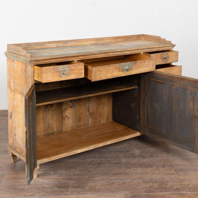 19th century Swedish sideboard crafted in pine with a unique storage configuration. The top includes three drawers, while...