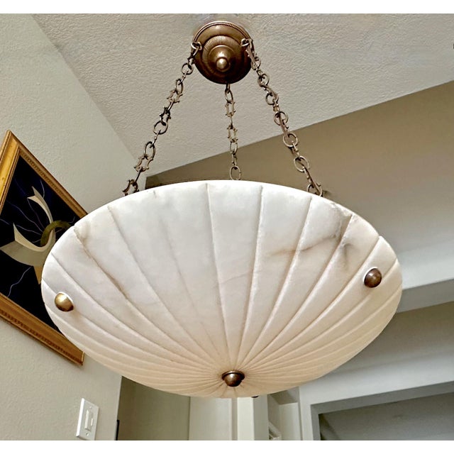 French alabaster pendant light with brass aged (antiqued finish) fittings in the Directoire style. Interior lighting uses...
