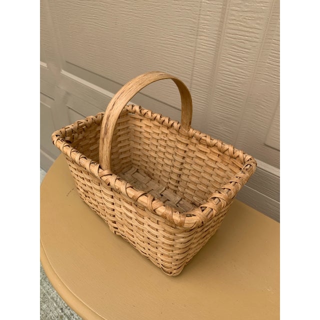 A beautifully woven early 20th century American splint oak basket with warm honeyed tones and a tightly constructed...