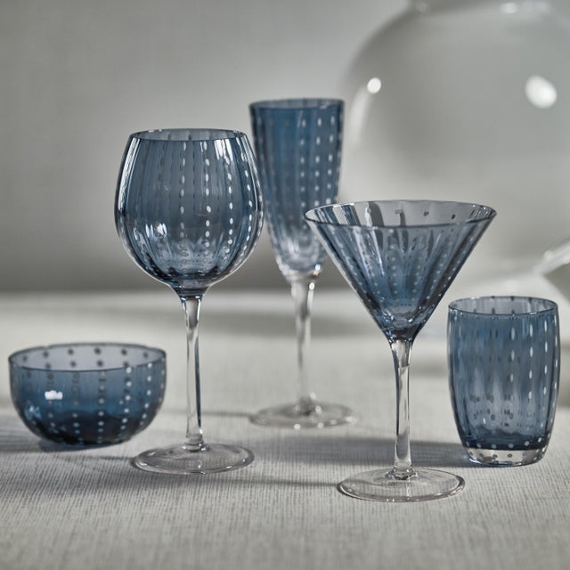 The Portofino White Dot Glassware in Navy Blue features elegant glassware with a sophisticated navy blue hue adorned with...