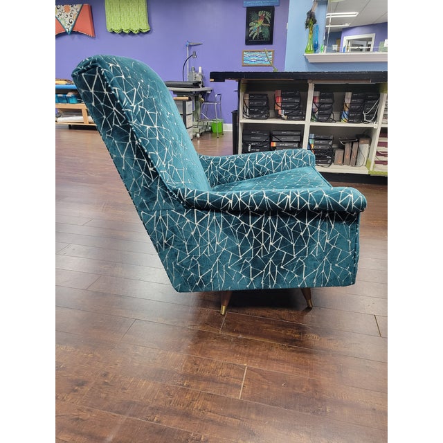 from mid century modern to modern icon, this swivel chair has been refreshed in teal geometric velvet, blending retro...