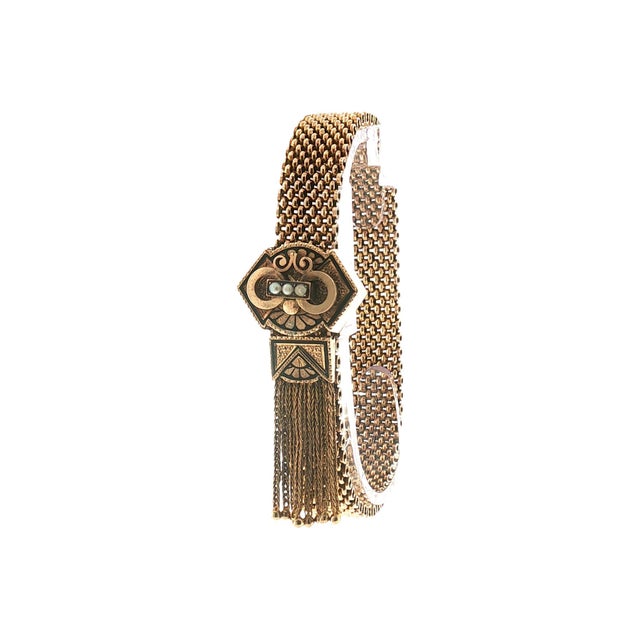 A Victorian slide bracelet crafted from 10k yellow gold and features 3 natural seed pearls and black enamel. The intricate...
