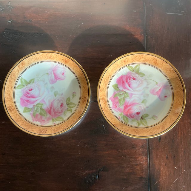 An elegant pair of vintage Royal Munich porcelain cabinet plates featuring romantic pink rose blossoms rendered in soft,...