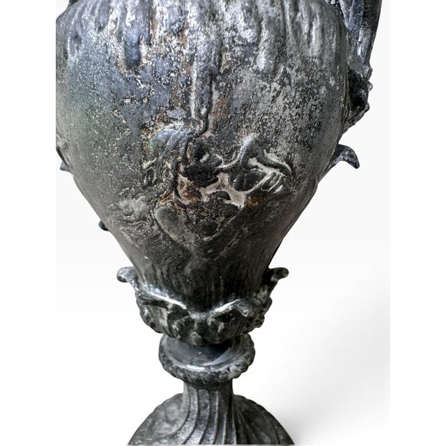 Elegant antique French cast-metal urn, approximately 9 inches tall, featuring an exceptional Neoclassical design with Art...