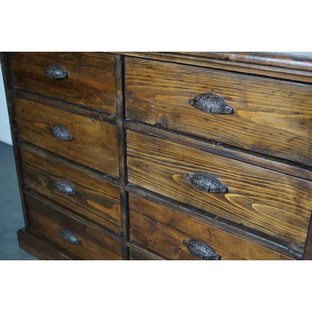 This stunning pine apothecary cabinet was made circa 1890s in France. It features 8 large drawers with ornate cast iron...
