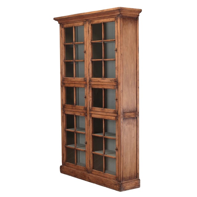 This tall pine cabinet blends European character with clean, timeless design. Featuring six glass-front doors and 14 fixed...