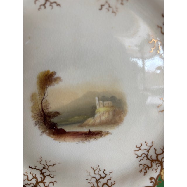 Set of 10 Antique porcelain dessert featuring a rich green ground with ornate gilt decoration and delicate scenic centers....