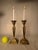 The motifs of sashes, bows and ribbon decorate the trapezoid shaped columns of this pair of solid brass candlesticks....