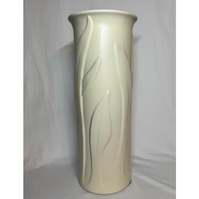 Vintage Haeger tall column vase with a relief pattern of layered foliage leaves that changes around the vase.. 19.75”...