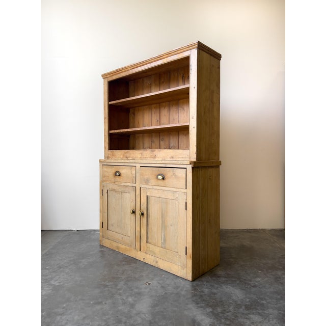 A primitive antique English pine hutch with lots of character! Deep upper shelves and ample lower cabinet storage make...