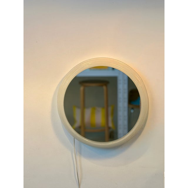 Round mirror of Egon Hillebrand from the 1960s with a frame made of colorless acrylic glass. Backlit with 3 bulbs...