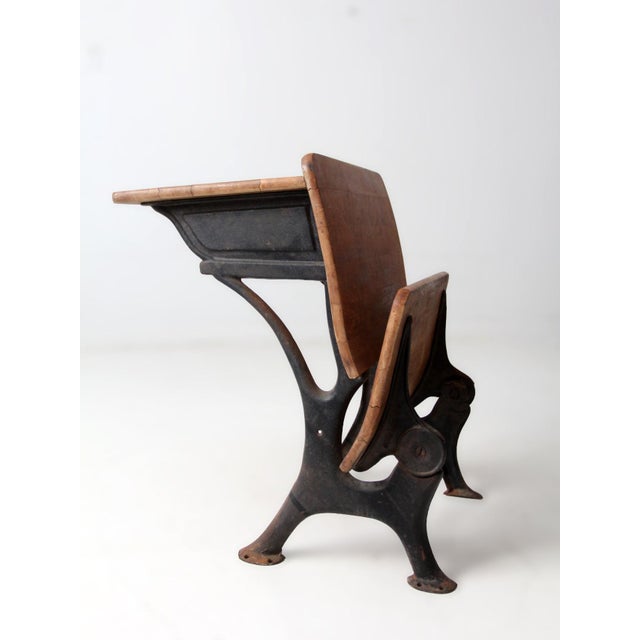 An early 20th century Chicago cast iron and wood school desk with arched iron supports and beautifully aged wood. The...