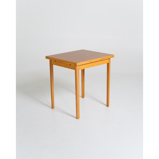 Rectangular wood-effect laminate tabletop, featuring two 25 cm extension leaves. Slender beech frame and legs. Swedish...