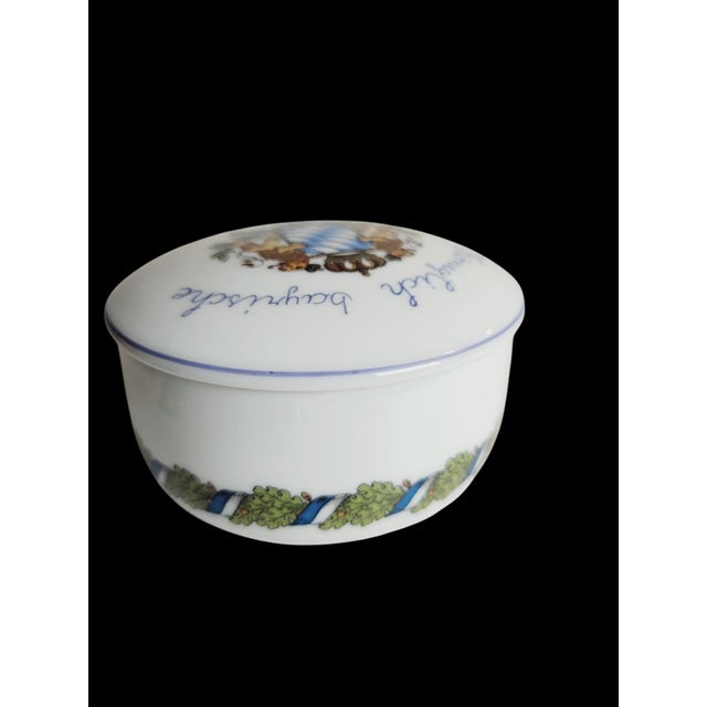 This porcelain trinket box epitomizes Bavarian craftsmanship with its intricate design and detailed artwork. The lid...