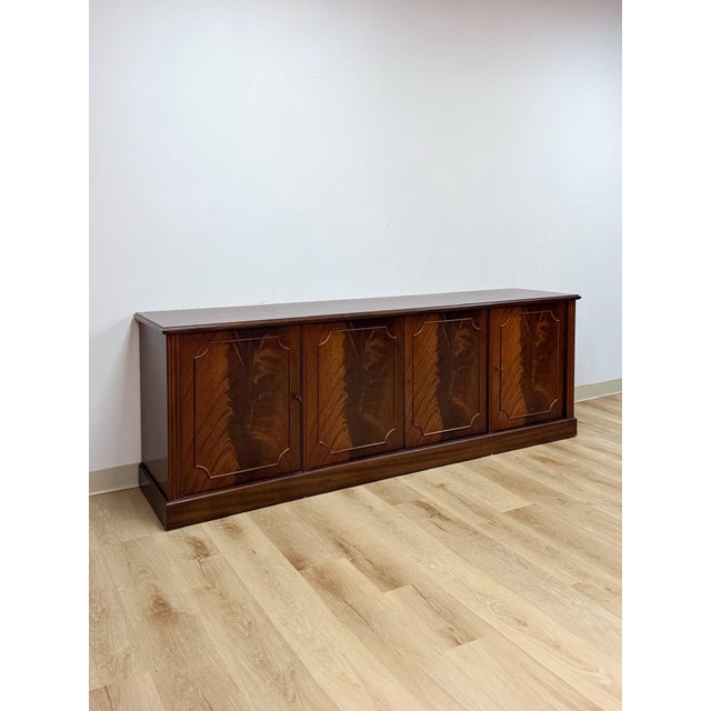 This mahogany credenza by Aurora showcases a refined transitional silhouette, finished in a rich, warm mahogany tone with...