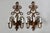Vintage pair of gold-finished wall sconces with intricate scrolling arms and candle covers. Cast metal with a distressed...