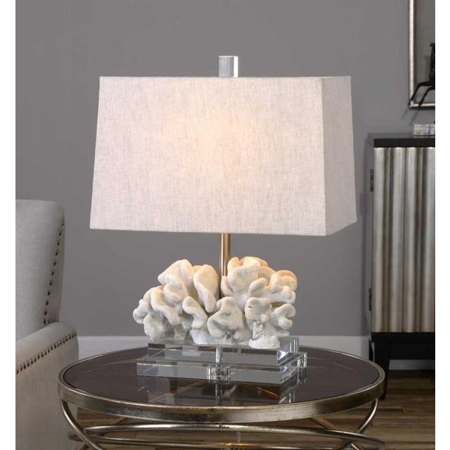 Taupe-ivory coral sculpture paired with a layered thick crystal foot and paired with brushed nickel plated accents. The...