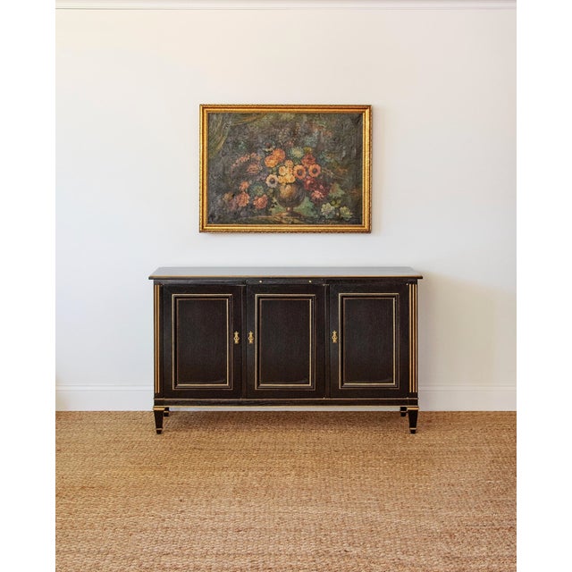 A sophisticated vintage ebonized sideboard inspired by French and English Neoclassical design, finished in a rich black...