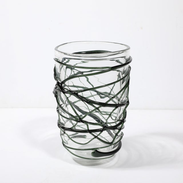 This striking hand-blown Murano glass vase features organic sculptural striations in a vibrant viridian green, showcasing...