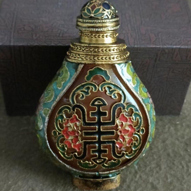 This is a beautifully crafted vintage Chinese cloisonné enamel snuff bottle, featuring a flattened, flask-like form with a...