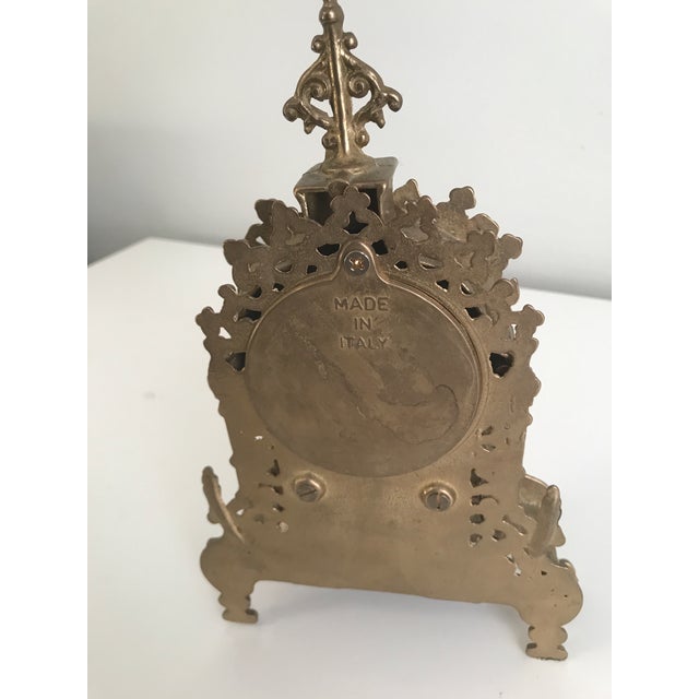 This is an ornate mantel clock featuring a design characteristic of the Rococo Revival style, popular from the late 19th...