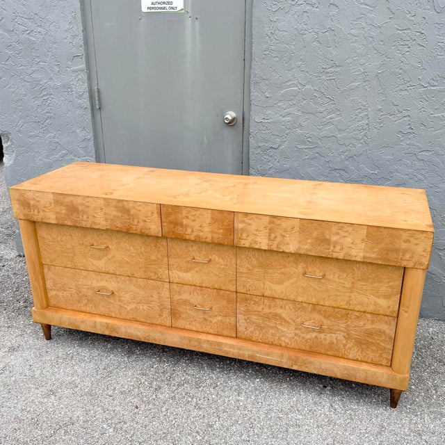 This striking Mid-Century Modern dresser showcases the rich visual character of burlwood veneer in a warm honey-toned...
