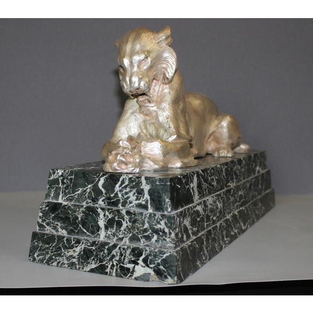 Lioness holding an antelope in her paws, silvered bronze and sea-green marble base, unsigned, circa 1930, in very good...