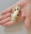 A finely modeled Japanese netsuke depicting a mischievous kappa clinging to a catfish. Carved from an early ivory-...