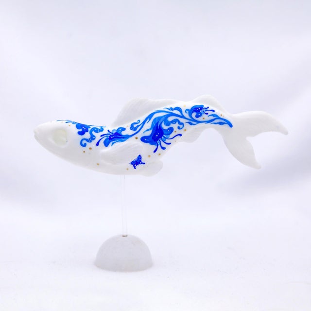 This artwork features a stylized fish, elegantly rendered in a glossy resin cast that captures the fluidity of movement....