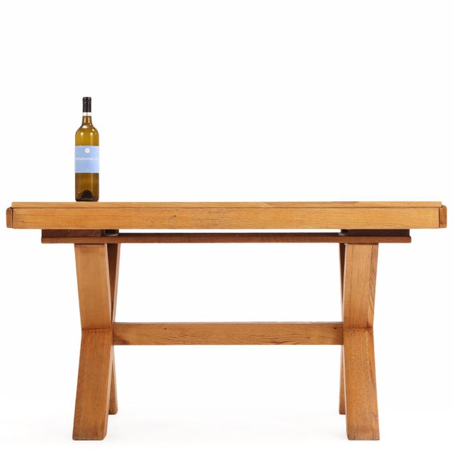 A substantial Belgian oak dining table distinguished by its bold X-form trestle base and clean architectural lines....