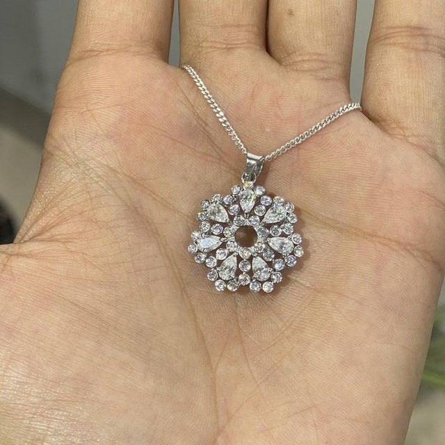This elegant pendant features 1.88 ct pear and round moissanites, handcrafted in 925 sterling silver. Designed in a...