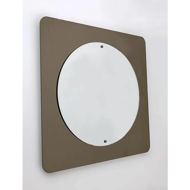 Imposing and elegant circular wall mirror in the center in silver glass, on smoky bronze colored mirrored glass in a...