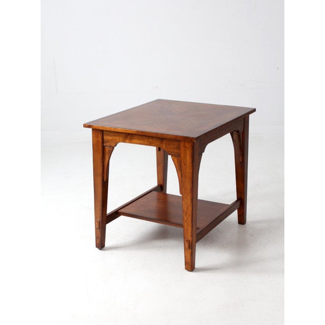 Blending Arts & Crafts and Mid-Century Modern influences, this vintage side table features a striking geometric veneer...