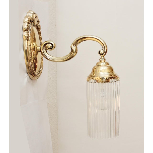 Pair of Art Nouveau Wall Lamps Two Art Nouveau wall lamps, circa 1915. Solid cast brass. Floral-decorated wall plate....