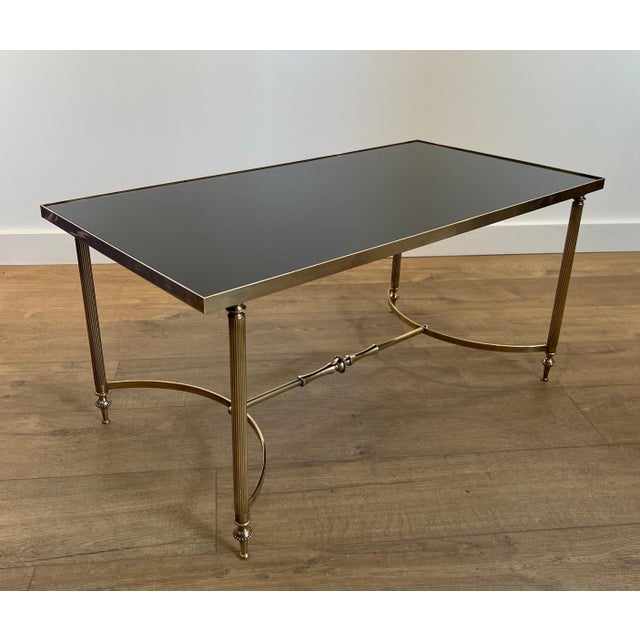 This beautiful rectangular coffee table is made of brass with a black lacquered glass top. It is a French work Attributed...