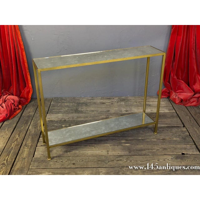 The Marcelo console table combines clean architectural lines with a refined gold-finished iron frame, complemented by an...