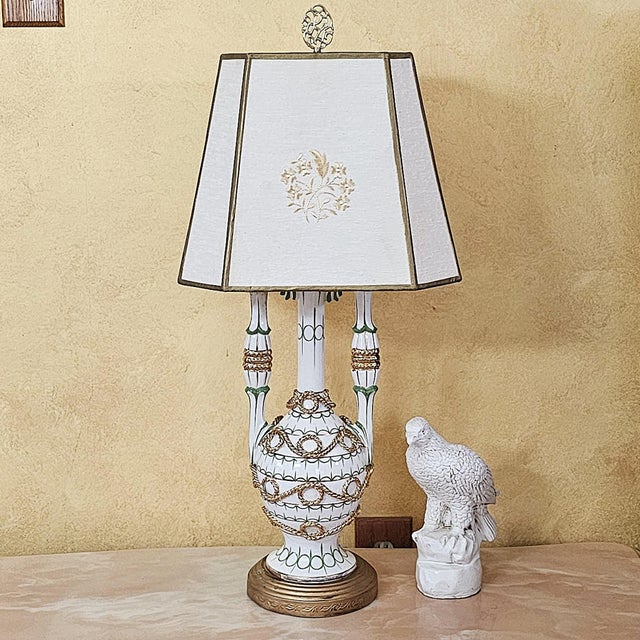 This striking mid‑century Capodimonte or Neoclassical‑style table lamp features an ornate ceramic urn‑form body richly...