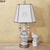 This striking mid‑century Capodimonte or Neoclassical‑style table lamp features an ornate ceramic urn‑form body richly...