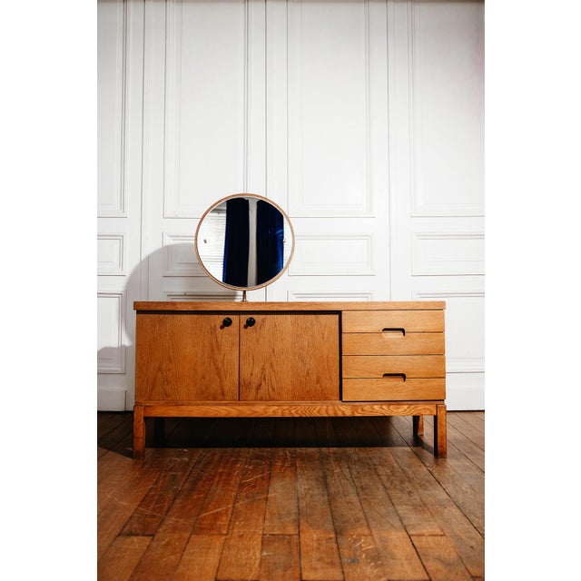 Oak veneer storage unit dating from the 1960s. Its design combines a storage space enclosed by two doors, three drawers,...