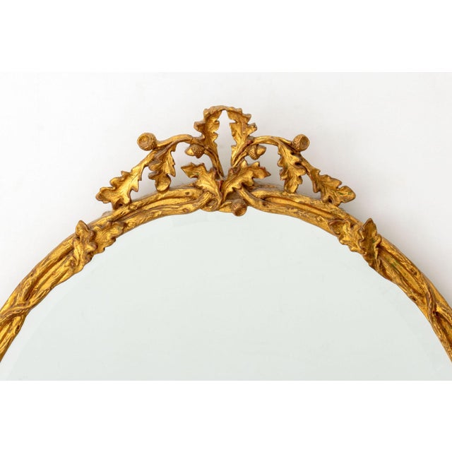Louis XVI Style Giltwood Framed Oval Beveled Glass Mirror. Mirror plate: 29" H x 23.5" W; frame: 36" H x 26.5" W....