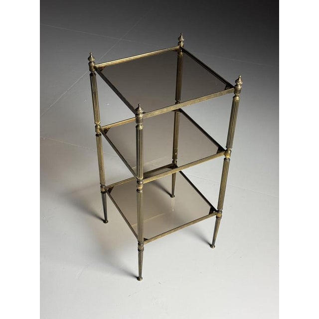 Vintage tiered side table. Originating from the mid-20th century. It has three shelves and smoked glass. Dimensions: 35W x...