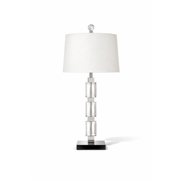 A striking modern table lamp defined by its sculptural stacked glass cube form and polished chrome accents. Clean,...