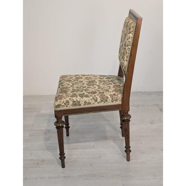 Antique Louis XVI-style chair from France, with a wooden frame and floral upholstery. Simple, elegant design with...