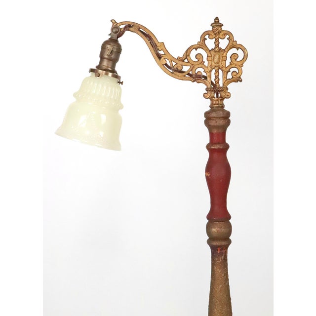 Victorian style bridge arm floor lamp made of cast iron and wood with a bell shaped glass shade. It features an adjustable...